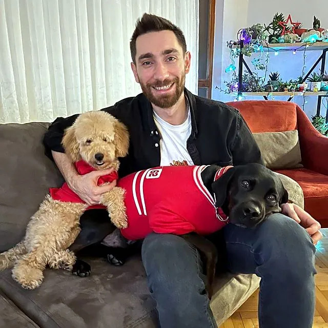 Dr Eren at home with a poodle and a black Labrador