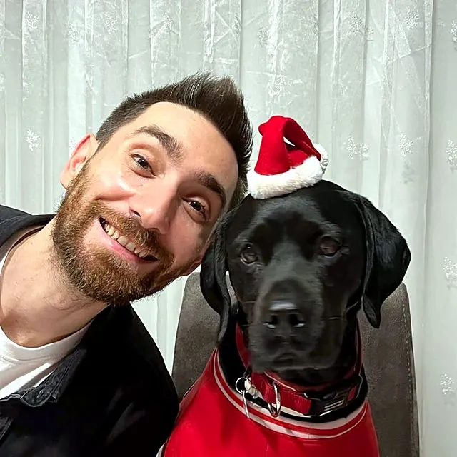 Dr Eren with a black Labrador in a Santa hat