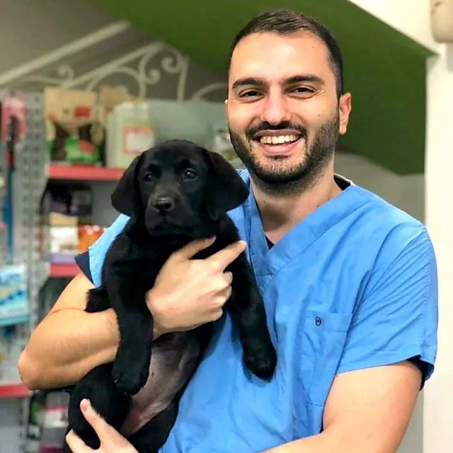 Dr Furkan with a black Labrador puppy