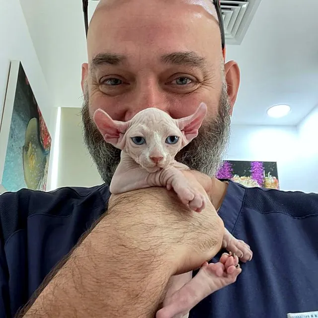 Dr Piotr holding a Sphynx kitten