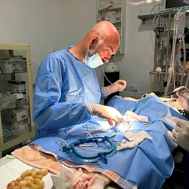 Dr Piotr operating under surgical lights