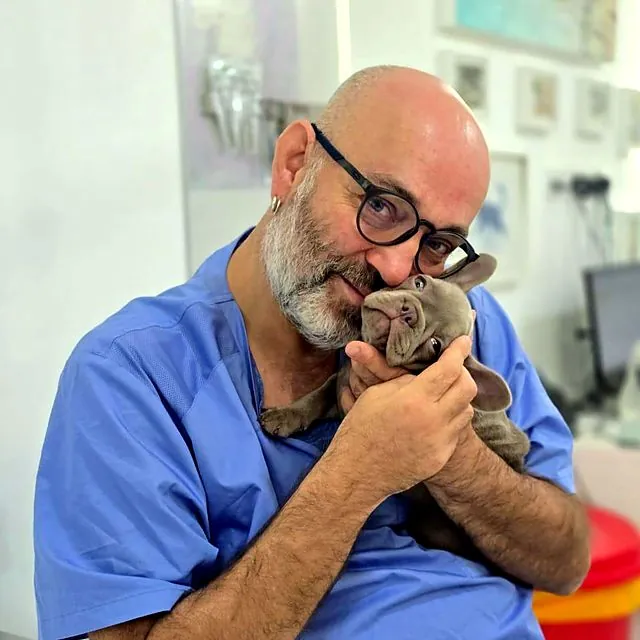 Dr Piotr cuddling a French bulldog puppy